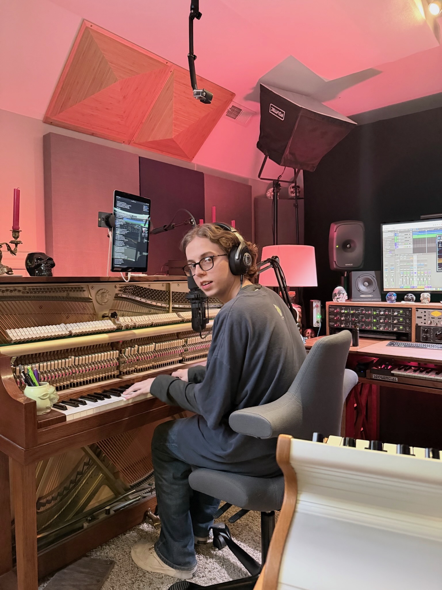Musician wearing headphones while playing the Sweetflow upright piano