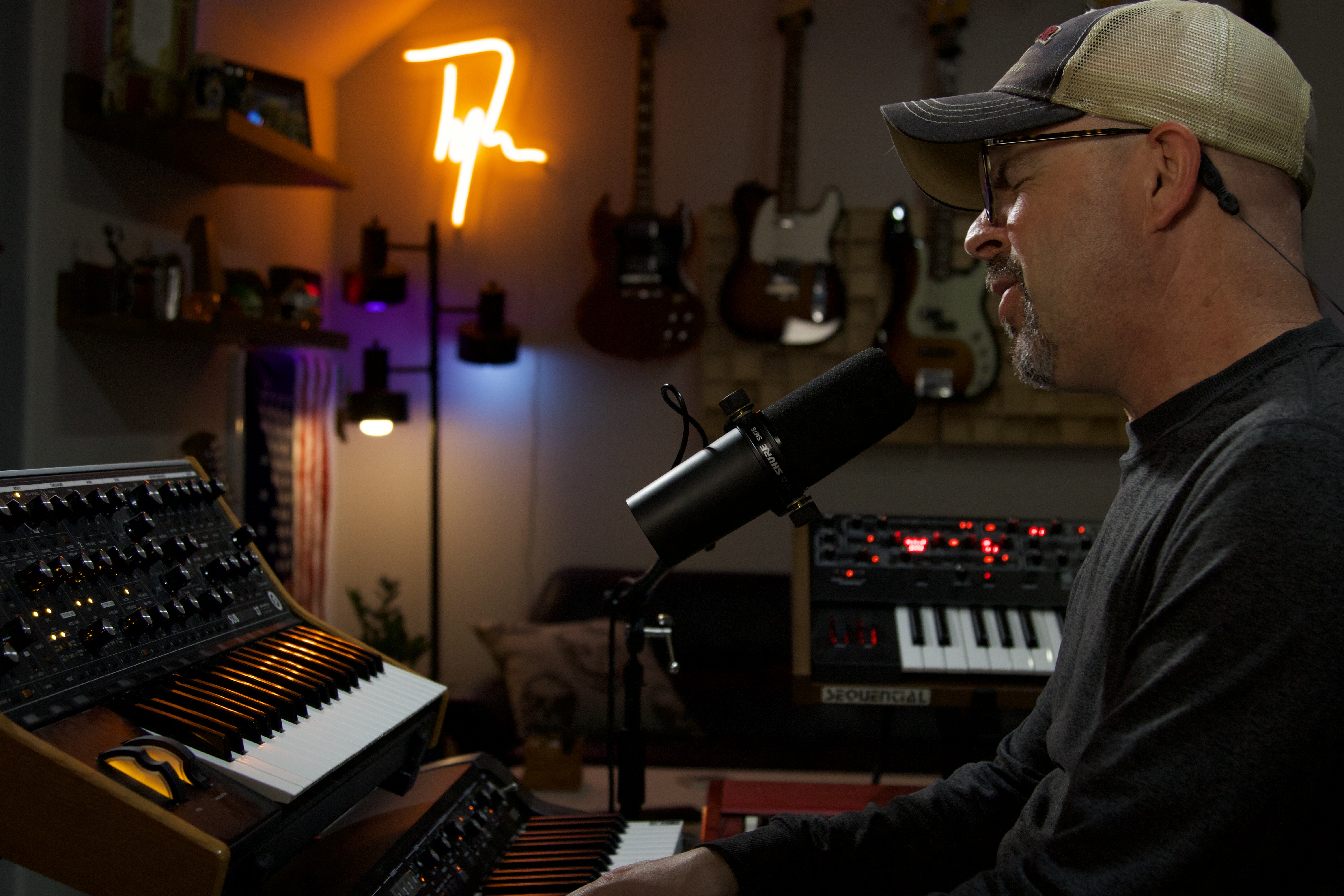 Tyler Bennett singing into a microphone at his keyboards in Sweetflow Studio